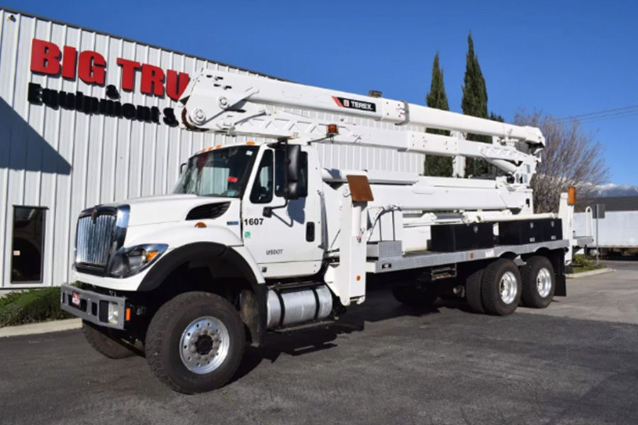A white bucket truck parked outside a building